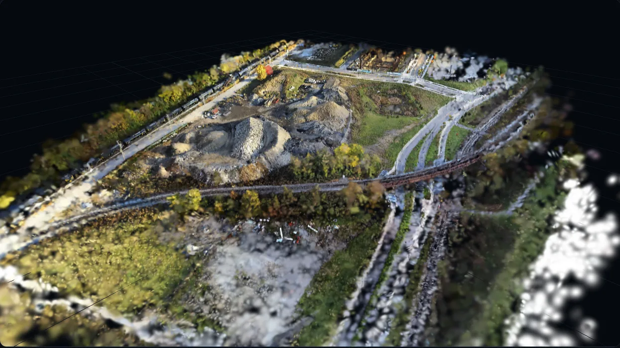 An aerial site rebuilt by Helios as a Gaussian splat, floating on black.