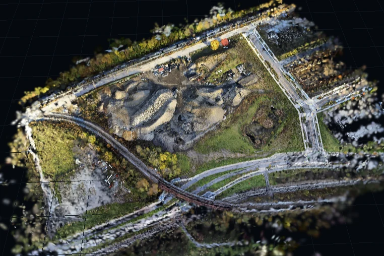 The same quarry scene looking down, with the rail line, access roads and cut faces visible.